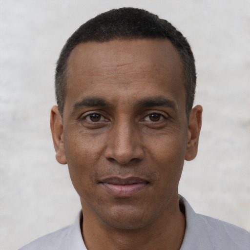 Joyful black adult male with short  black hair and brown eyes