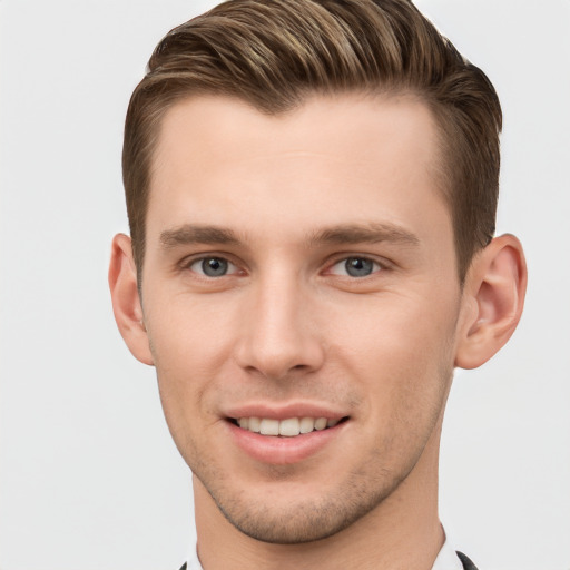 Joyful white young-adult male with short  brown hair and grey eyes