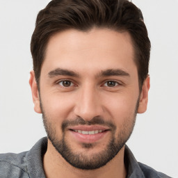 Joyful white young-adult male with short  brown hair and brown eyes