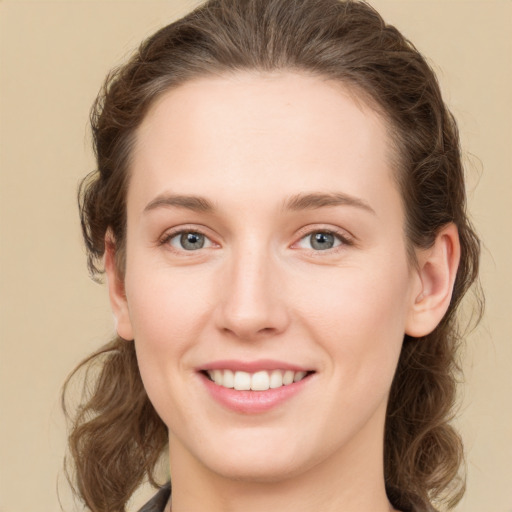 Joyful white young-adult female with medium  brown hair and green eyes