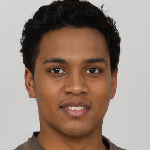 Joyful black young-adult male with short  brown hair and brown eyes