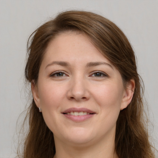 Joyful white young-adult female with long  brown hair and grey eyes