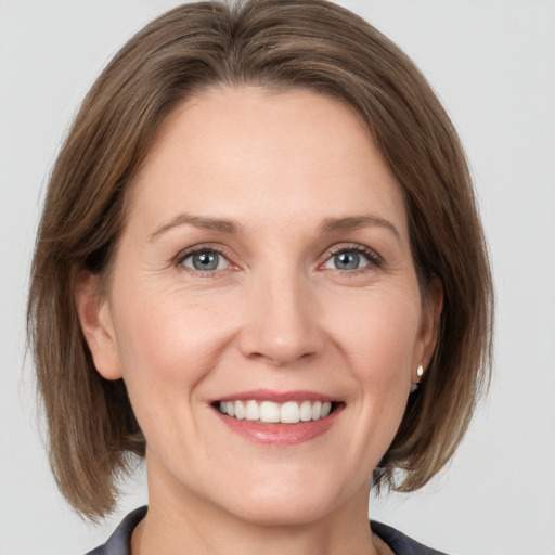 Joyful white adult female with medium  brown hair and grey eyes