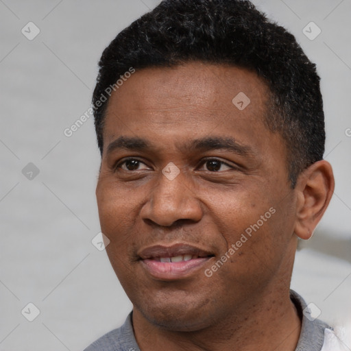 Joyful black adult male with short  black hair and brown eyes