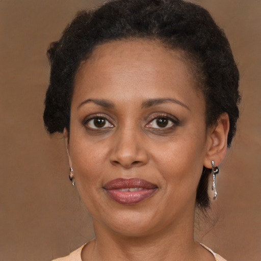 Joyful black adult female with medium  brown hair and brown eyes