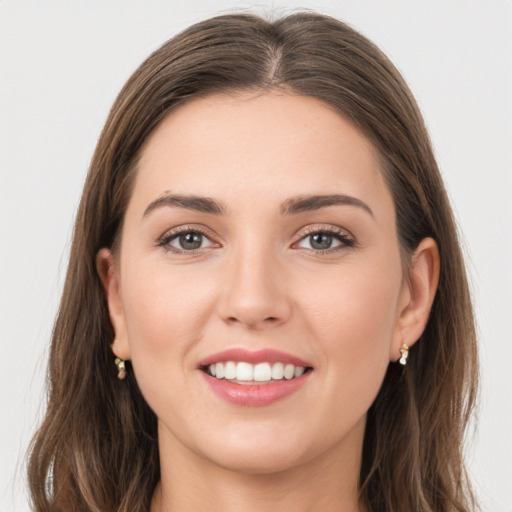 Joyful white young-adult female with long  brown hair and grey eyes