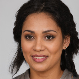 Joyful latino adult female with medium  brown hair and brown eyes