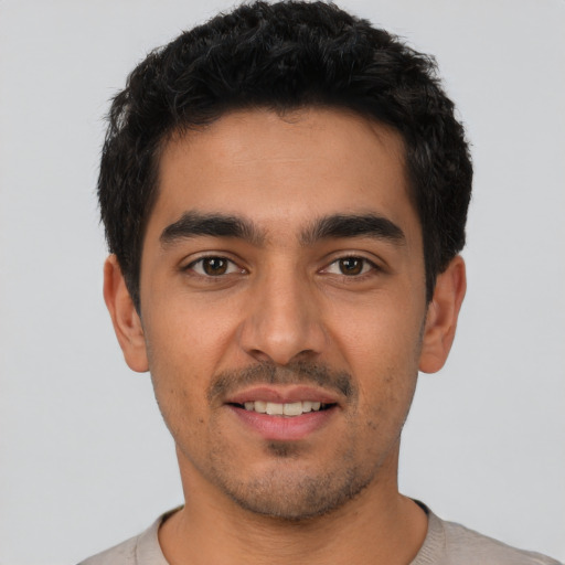 Joyful latino young-adult male with short  black hair and brown eyes