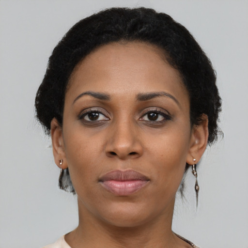 Joyful black young-adult female with short  black hair and brown eyes