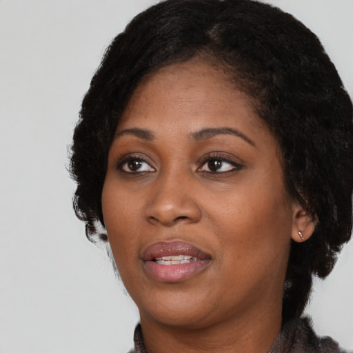 Joyful black adult female with medium  black hair and brown eyes