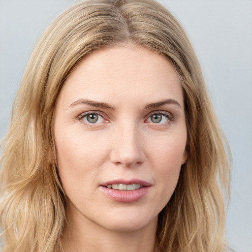 Joyful white young-adult female with long  brown hair and blue eyes