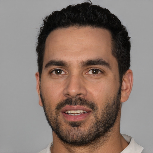 Joyful white young-adult male with short  black hair and brown eyes