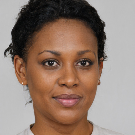 Joyful black adult female with short  brown hair and brown eyes