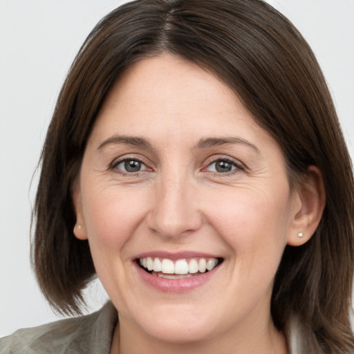 Joyful white adult female with medium  brown hair and grey eyes