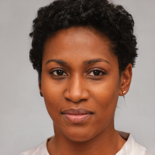 Joyful black young-adult female with short  black hair and brown eyes