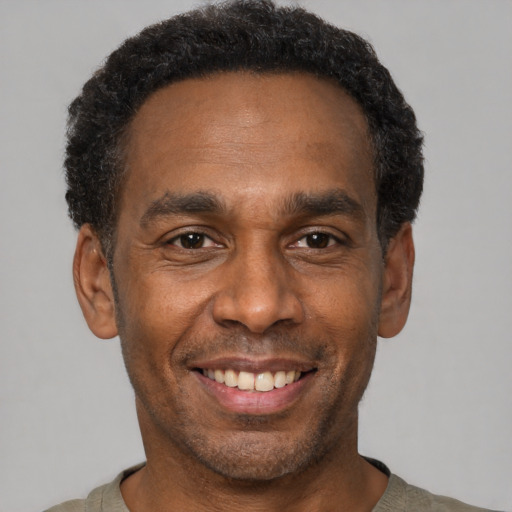 Joyful black adult male with short  black hair and brown eyes