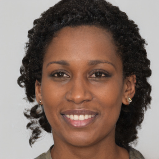 Joyful black adult female with medium  brown hair and brown eyes