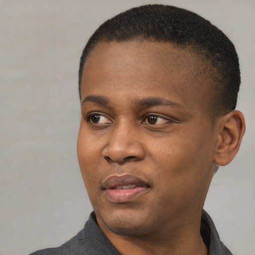 Joyful black young-adult male with short  black hair and brown eyes