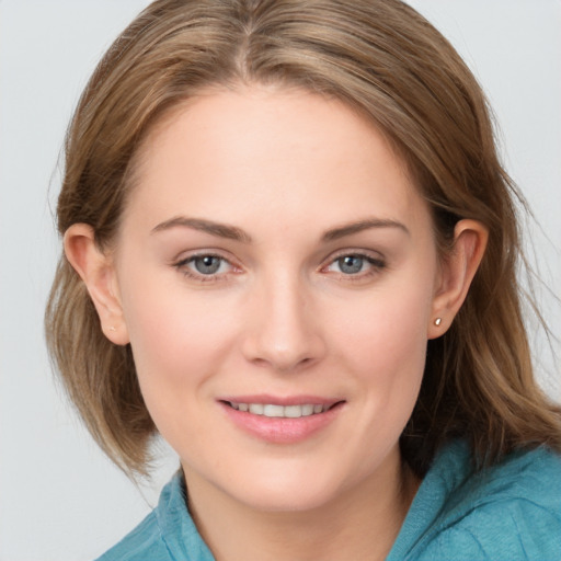 Joyful white young-adult female with medium  brown hair and grey eyes