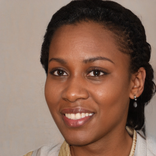 Joyful black young-adult female with short  black hair and brown eyes