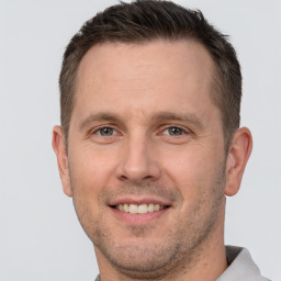 Joyful white adult male with short  brown hair and brown eyes