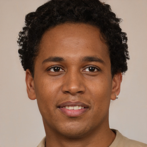 Joyful black young-adult male with short  brown hair and brown eyes