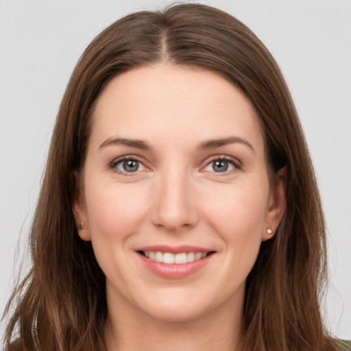 Joyful white young-adult female with long  brown hair and grey eyes