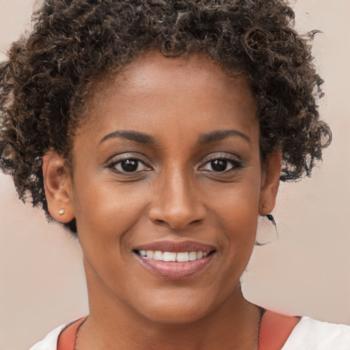 Joyful black young-adult female with short  brown hair and brown eyes