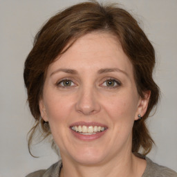 Joyful white adult female with medium  brown hair and blue eyes