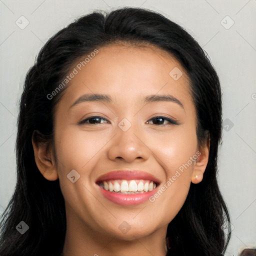 Joyful latino young-adult female with long  black hair and brown eyes