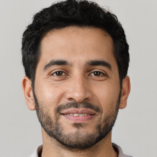 Joyful latino young-adult male with short  black hair and brown eyes