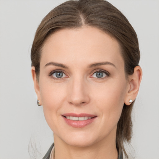 Joyful white young-adult female with medium  brown hair and grey eyes