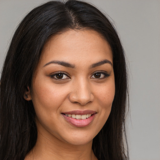 Joyful latino young-adult female with long  brown hair and brown eyes