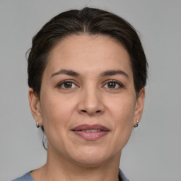 Joyful white adult female with medium  brown hair and grey eyes