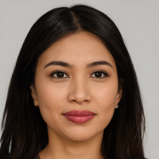Joyful latino young-adult female with long  brown hair and brown eyes