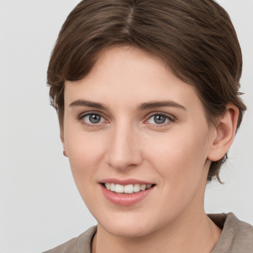 Joyful white young-adult female with short  brown hair and grey eyes