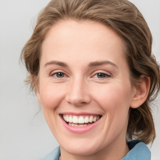 Joyful white young-adult female with medium  brown hair and blue eyes