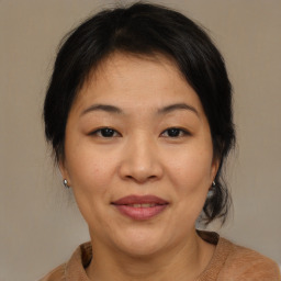 Joyful asian adult female with medium  brown hair and brown eyes