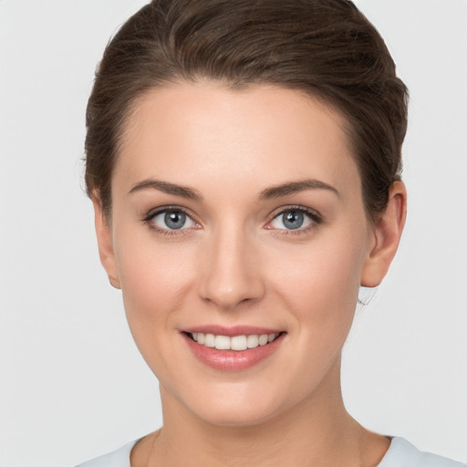 Joyful white young-adult female with short  brown hair and grey eyes