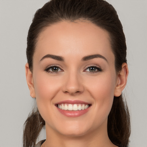 Joyful white young-adult female with long  brown hair and brown eyes