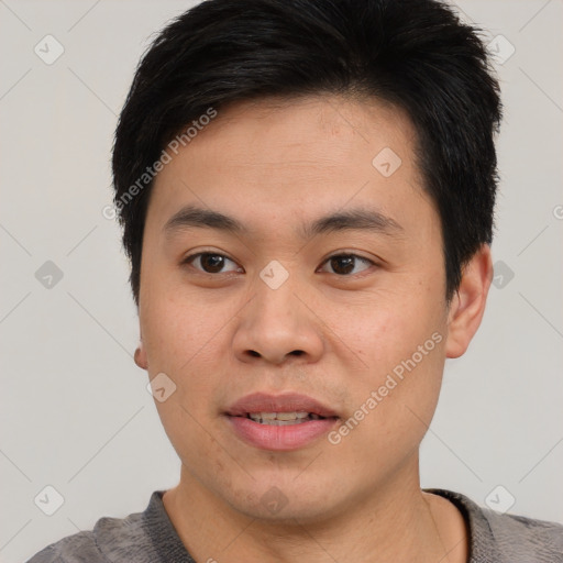 Joyful asian young-adult male with short  brown hair and brown eyes