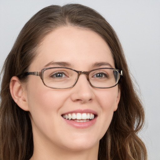 Joyful white young-adult female with long  brown hair and blue eyes