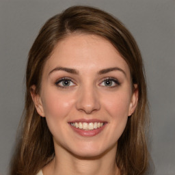 Joyful white young-adult female with long  brown hair and green eyes