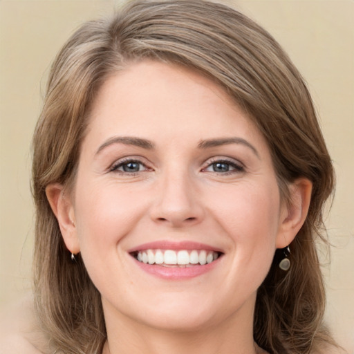 Joyful white young-adult female with medium  brown hair and green eyes