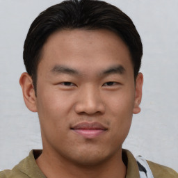 Joyful asian young-adult male with short  brown hair and brown eyes