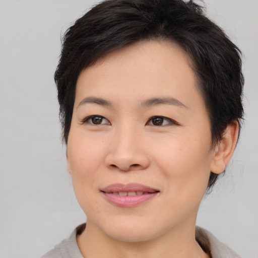 Joyful asian young-adult female with short  brown hair and brown eyes