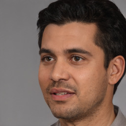 Joyful white young-adult male with short  black hair and brown eyes