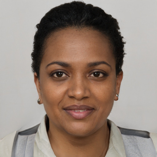 Joyful black young-adult female with short  black hair and brown eyes