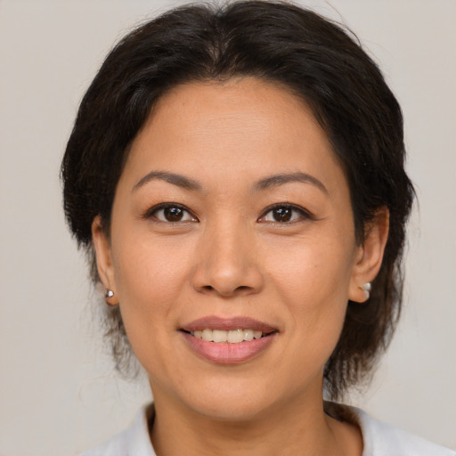 Joyful asian adult female with medium  brown hair and brown eyes