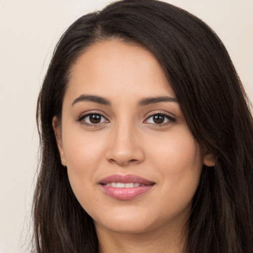 Joyful latino young-adult female with long  brown hair and brown eyes